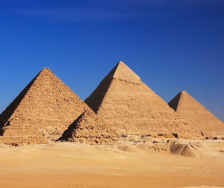 Three major pyramids of the Giza pyramid complex rising from the desert in Egypt.