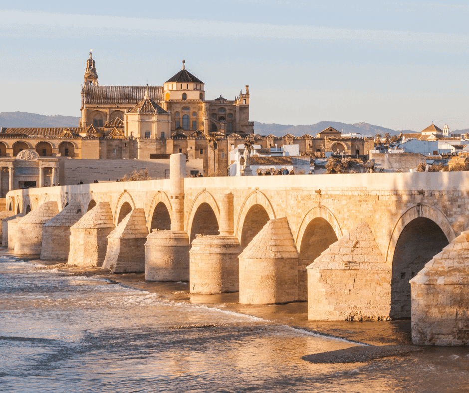 Roman Bridge over the Guadalquivir River in Córdoba, Spain with the Mezquita cathedral in the background at golden hour