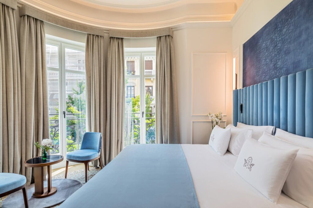 Elegant guest room with high ceilings and neutral tones at Palacio Gran Vía, Granada