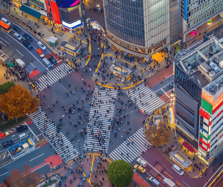 Aerial view of Shibuya scramble crossing in Tokyo Japan with crowds of pedestrians crossing in all directions surrounded by city buildings