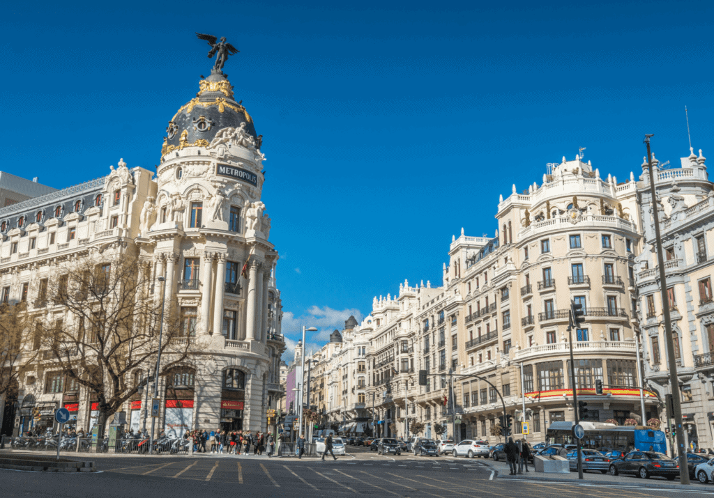 Metropolis Building and Gran Vía street in Madrid, Spain with elegant architecture under a bright blue sky