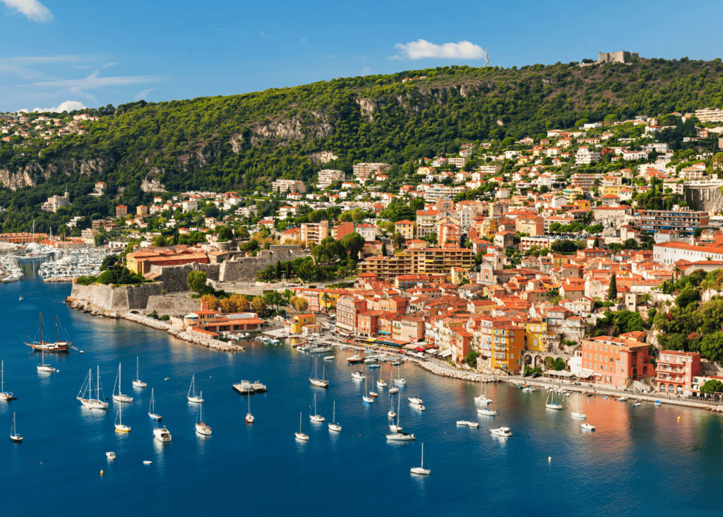 Villefranche-sur-Mer harbor on the French Riviera with sailboats, colorful waterfront buildings and hillside views