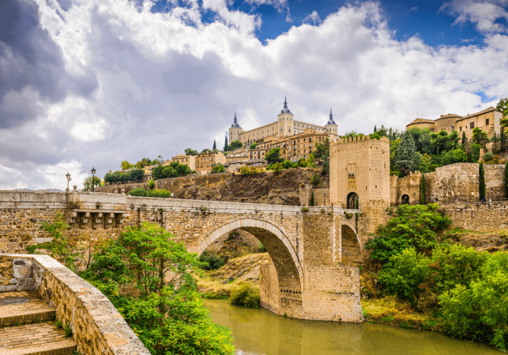 Historic stone bridge and Alcázar fortress overlooking the Tagus River in Toledo, Spain