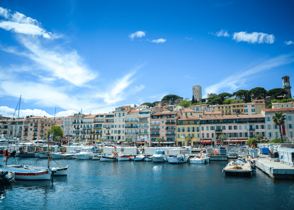 Cannes France old port with boats, colorful waterfront buildings and Le Suquet hilltop quarter on the French Riviera