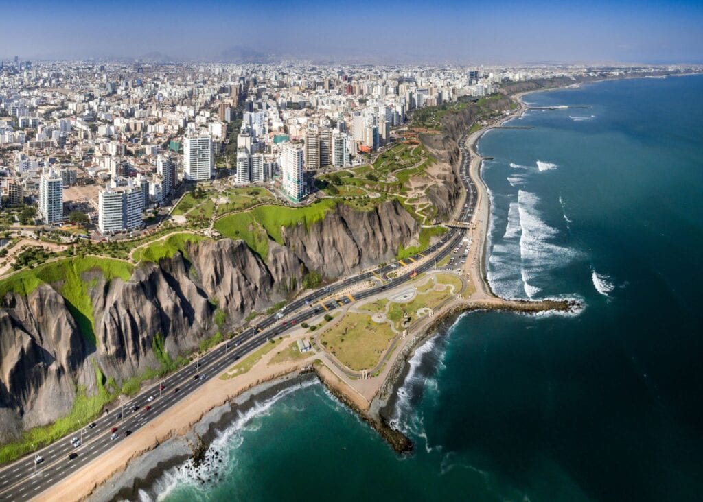 Lima coastline Alt text: Aerial view of the Miraflores district of Lima Peru with white city buildings stretching along dramatic coastal cliffs above the Pacific Ocean