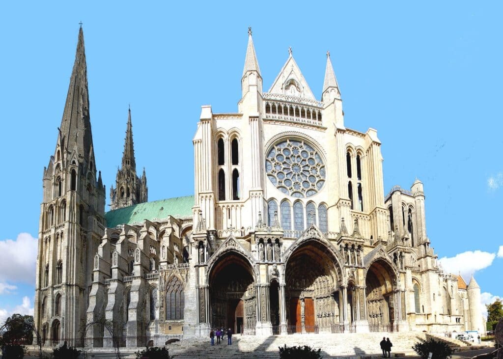 The west facade of Chartres Cathedral with its large rose window twin spires and elaborately carved triple portal entrance