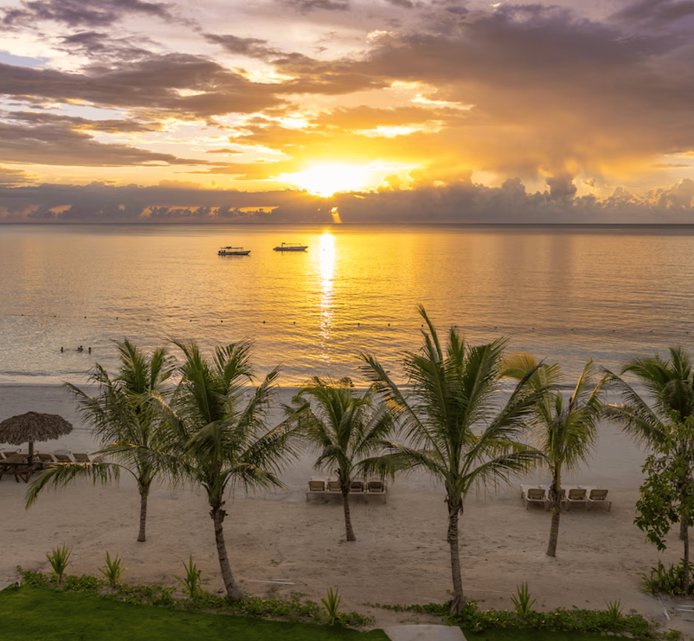 Sunset over the white sand beach and calm Caribbean Sea at Beaches Negril resort in Jamaica.